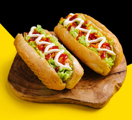 Two delicious hotdogs on wooden board
