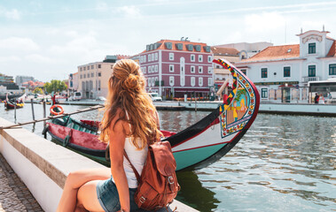 Woman tourist in Portugal- Aveiro- traditional boat in the canal