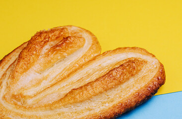 Puff pastry cookie on blue and yellow background