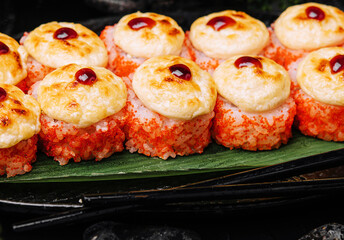Warm Sushi Roll with Salmon and Cream Cheese served on a black board
