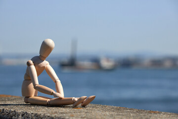 大阪湾の沿岸の公園の堤防で座っているマネキン人形