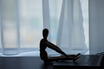 木製のマネキン人形とノートパソコン