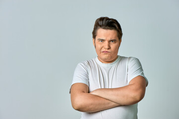 Angry, frowning man on a gray background, copy space