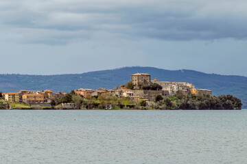 Fototapeta na wymiar The promontory on Lake Bolsena on which Capodimonte is located, Italy, under a dramatic sky