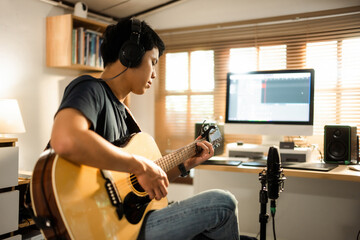 Asian man making music at home studio - obrazy, fototapety, plakaty