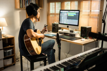 Fototapeta na wymiar Asian man making music at home studio