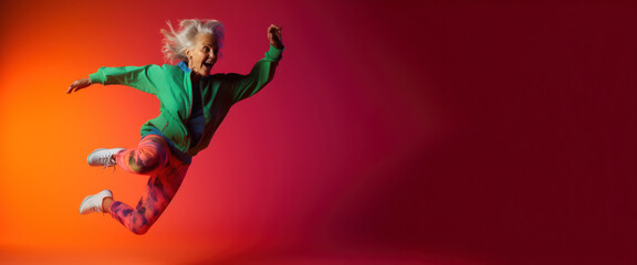 Modern Aging. A playful, energetic portrait of an older woman in workout clothes jumping for joy on a colorful gradient background. Generative AI