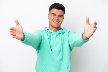 Young caucasian handsome man isolated on white background presenting and inviting to come with hand