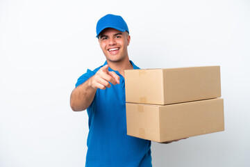 Delivery caucasian man isolated on white background surprised and pointing front