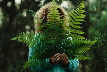 Natural lifestyle and love for nature people concept healthy lifestyle. Green leaves and woman behind. Forest in background. Outdoors healthy leisure activity. Environment and earth's day celebration