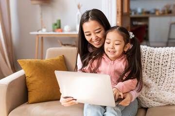 Korean Mom And Daughter Using Laptop Computer Sitting At Home