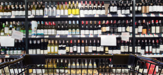 Abstract blurred image of alcohol store with trolley in department store. (Selective focused at shopping cart)	