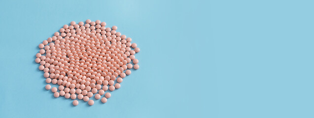 BPink pills on a blue background. Prescription drugs and pills. Lots of free space, banner.
