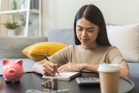 Saving Money Wealth Concept, Asian Young Business Woman Hand Write Management Budget For Saving Cost, Cash Finance Planning To Spend Enough Money On Her Income For Save Money, Payment Tax, Investing.