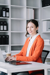 Female caucasian sitting at the desk, looking to camera.