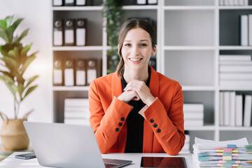 Female caucasian sitting at the desk, looking to camera.