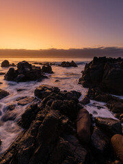 Beautiful sunrise glow around the rocky coastline.