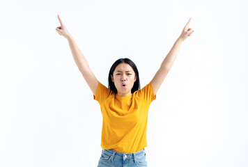Young excited Asian woman in yellow t-shirt raised her hands up feels a sense of victory, won the lottery, got good news, happy for success standing isolated on white background. Winner gesture - obrazy, fototapety, plakaty