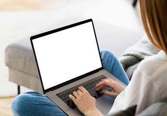 Young woman using laptop with blank screen. Female watching webinar, training or online works. Copy...