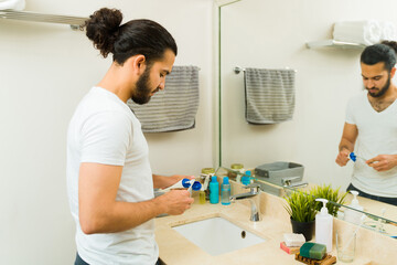 Attractive young man brushing his teeth