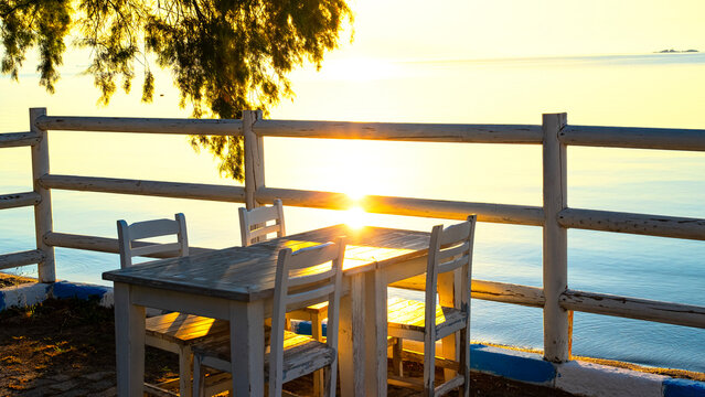 An authentic restaurant with a sea view on the Aegean coast of Turkey, overlooking the sea and among the trees, sunrise blue and orange colors