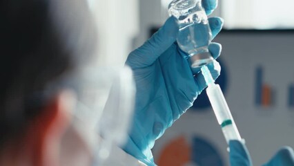 A doctor in a medical laboratory types a doctor into a syringe for injection in a close-up. Laboratory tests on the video show the process of testing for a new drug. Chemical research - Powered by Adobe