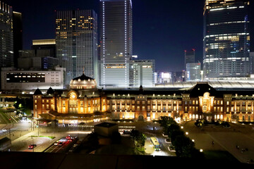 Fototapeta na wymiar 夜にライトアップされた東京駅の駅舎と丸の内の高層ビルと幻想的な夜景・デートスポット（東京都千代田区） 