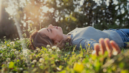 Relaxed woman resting on the grass - 600118388