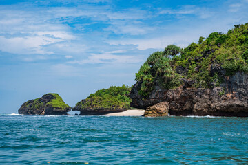 Fototapeta na wymiar Rock formation on the ocean near the Tanjung Kasap or Cape Kasap, Pacitan, Indonesia. Taken from a moving boat.