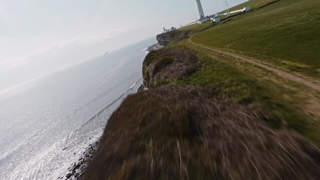 FPV Aerial drone footage of a lighthouse on A cliff side coast, south wales NASHPOINT UK