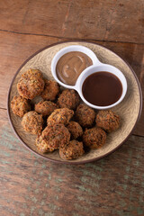 appetizer portion of pub tapas meatloaf dumpling or mini kafta kibis with black mustard and barbecue sauce on rustic wooden table top view