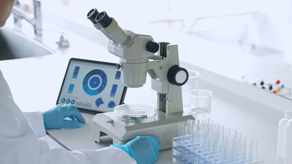 A man observing with a microscope. Scientific experiment.