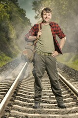 Adventurer with retro haversack wandering nature on railroad way
