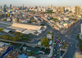 Aerial view of Hua Lamphong or Bangkok Railway Terminal Station with skyscraper buildings in urban city, Bangkok downtown skyline, Thailand. Cars on traffic street road on highways.
