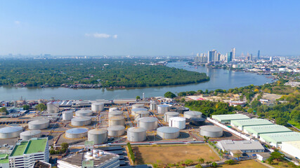 Naklejka premium Aerial view of petrochemical oil refinery and sea in industrial engineering concept in Bangna district at night, Bangkok City, Thailand. Oil and gas tanks pipelines in industry. Modern metal factory.