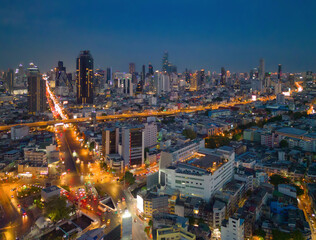 Obraz premium Aerial view of Bangkok Downtown skyline, highway roads or street in Thailand. Financial district and business area in smart urban city. Skyscraper and high-rise buildings at night.
