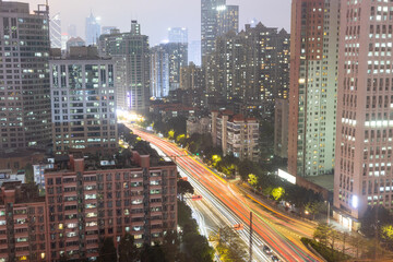 Naklejka premium modern complex and traffic along on busy road in evening with high-rise building in Guangzhou city, China