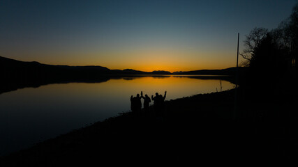 Fototapeta na wymiar sunset over the lake. People watching the sunset over the lake as the sun sets in the evening