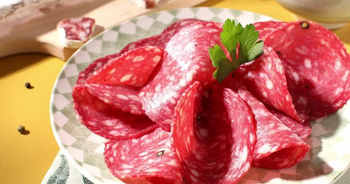 slices sausage salchichon on a plate. salami on a cutting board. cold cuts with bread and tomatoes. traditional spanish and italian sausages. meat delicacies antipasto on the table. 