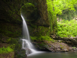 Fototapeta premium Fascinating forest waterfall. River flowing through a hole in a rock. Murgul Deliklikaya Waterfall. Black sea region. Baskoy village of Artvin. Turkey