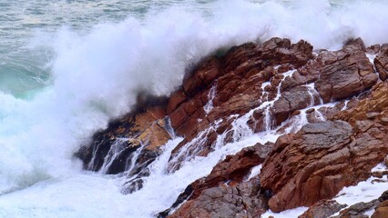 closeup of ocean waves crashing on rocks 