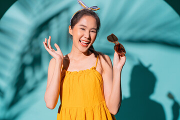 summer casual freshness asian woman yellow summer dress hand gesture smiling confident portrait look at camera studio shot on blue colour background,standing attractive asia teen female summer style