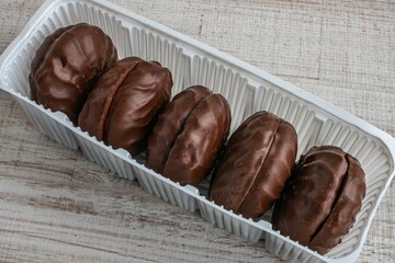 Chocolate marshmallows in a package. A box of marshmallows in chocolate glaze close-up lying on the table. The concept of children's caries from candies and sweets
