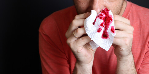 Man holding a bloody handkerchief in his hand, closeup