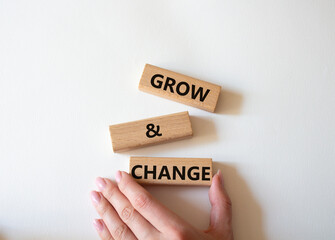 Grow and Change symbol. Concept word Grow and Change on wooden blocks. Businessman hand. Beautiful...