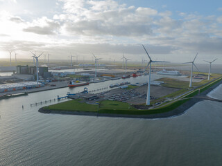 Discover the fascinating connection between wind energy and maritime trade with an unforgettable aerial footage of Eemshaven port, showcasing the harmonious coexistence of wind turbines, ships, and