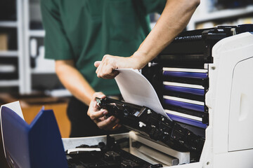 Technician hand open cover photocopier or photocopy to fix repair copier paper jam and replace ink...