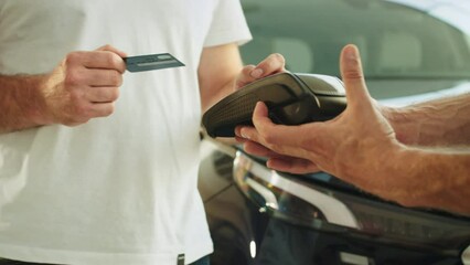 Cropped man customer buyer client male hand hold wireless bank payment terminal process acquire credit card payments buy automobile in car showroom vehicle salon dealership store motor show indoor.