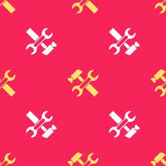 Yellow Crossed hammer and wrench spanner icon isolated seamless pattern on red background. Hardware tools. Vector