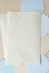 decorative paper sheets with embossed texture featuring flowers on abstract seals with pointed edges or petals on beige